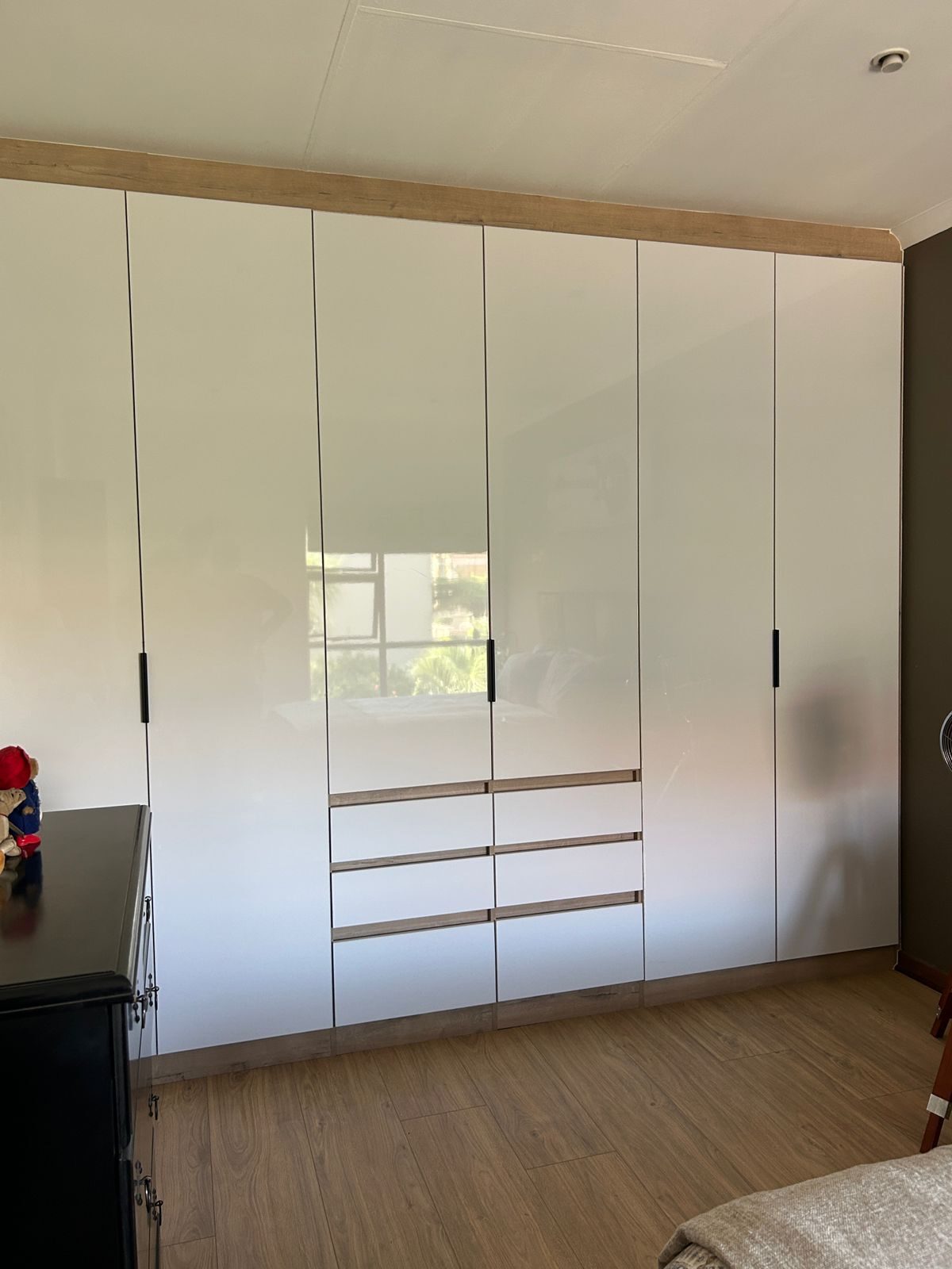 White gloss built-in wardrobe with timber trim